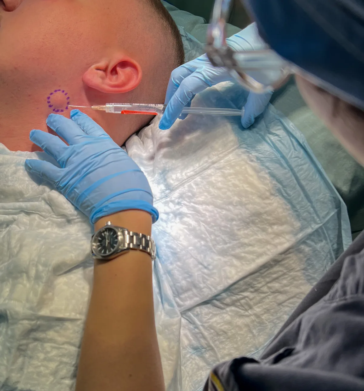 Dr. Brahe performing a dermatologic injection procedure on a patient